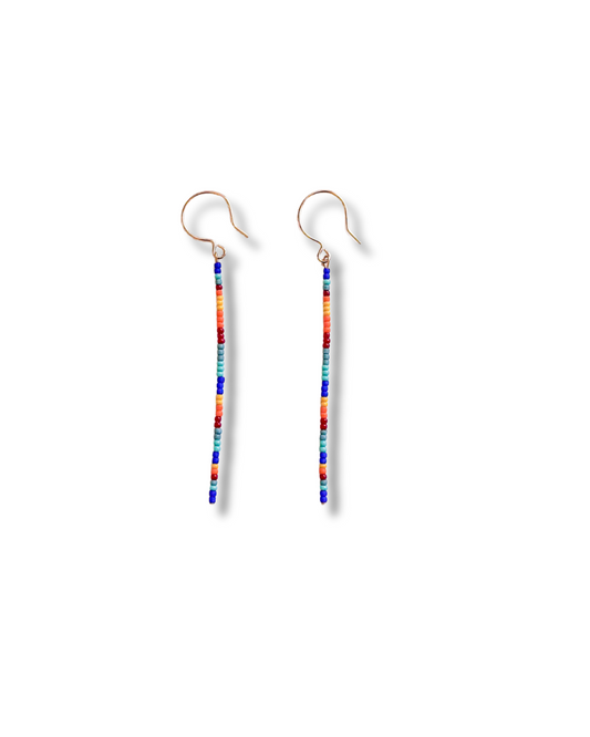 Rainbow Thread earrings with minimalist vertical lines of colorful seed beads in cobalt, teal, orange, red, and violet—suspended from gold-plated hooks for a sleek, lightweight look.
